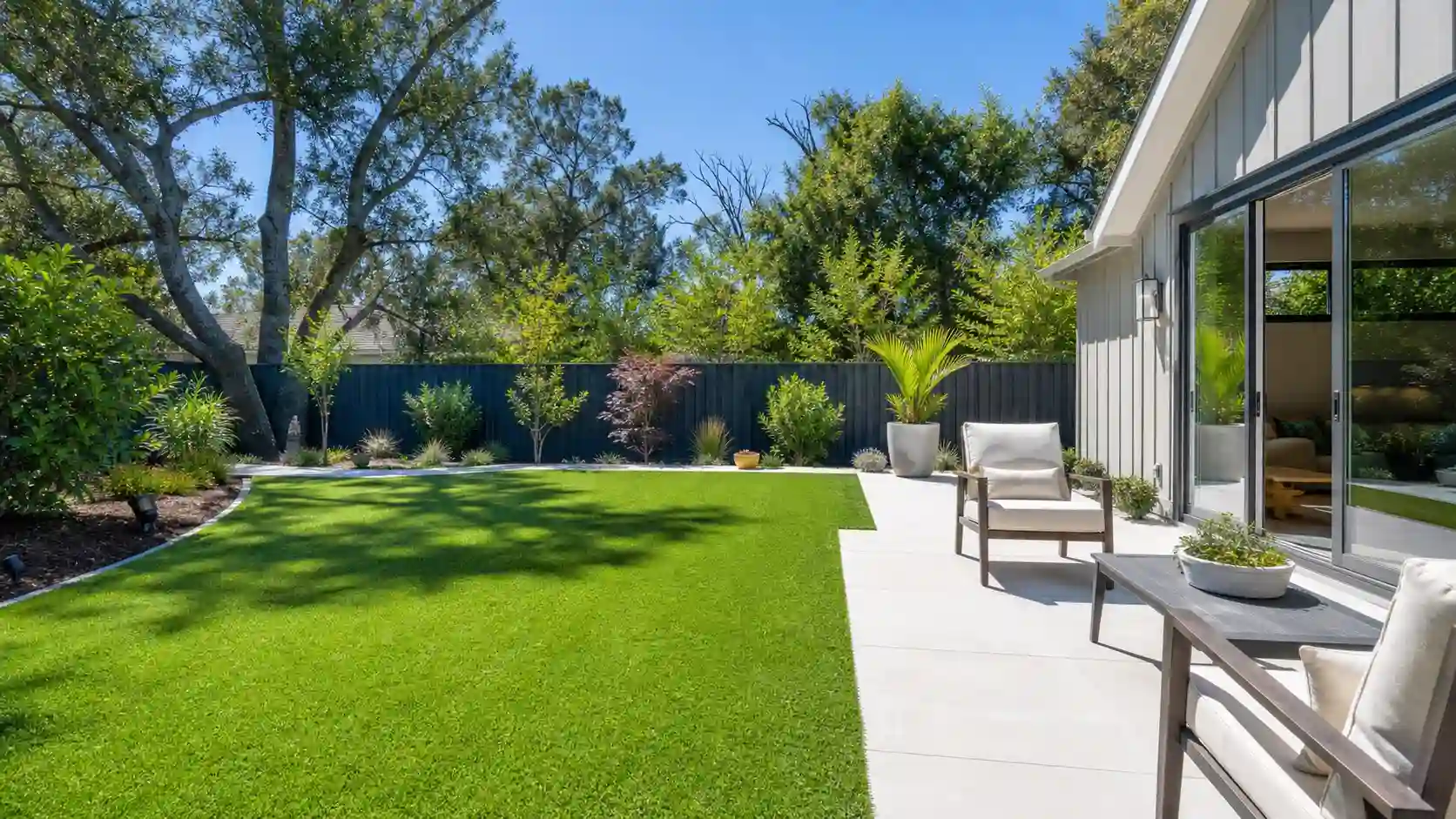 Backyard with green artificial turf and patio seating, showing the pros and cons of artificial turf for a real San Diego home.